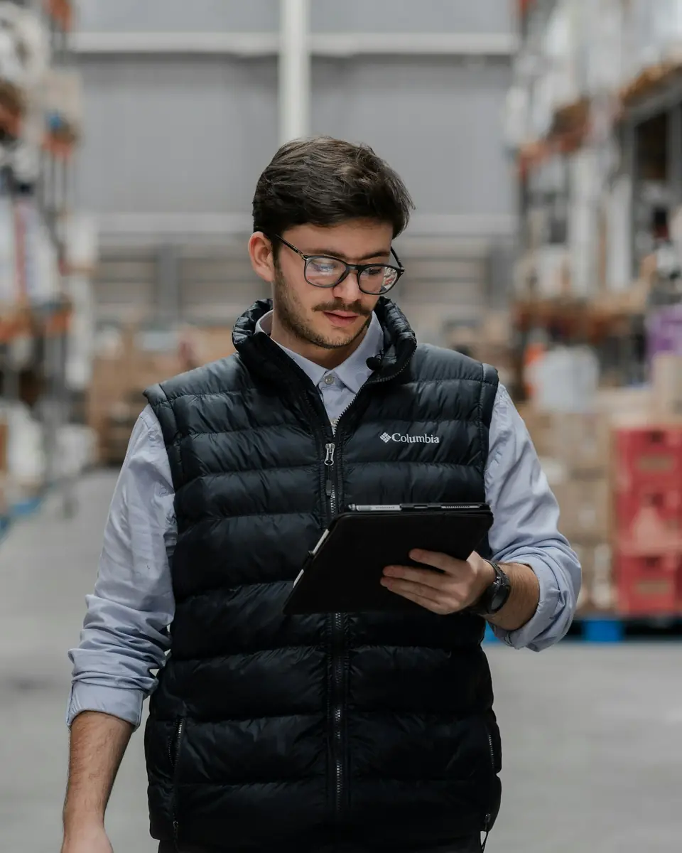 Operations supervisor reviewing a dispatch plan on a tablet in the warehouse